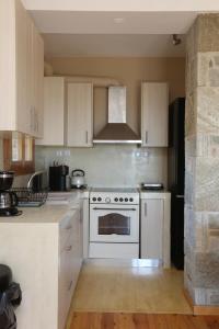a kitchen with white cabinets and a stove top oven at Magna Grecia Residence Panoramic View in Episkopíon