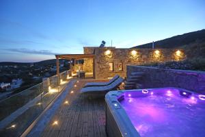 a hot tub on the deck of a house at night at Magna Grecia Residence Panoramic View in Episkopíon