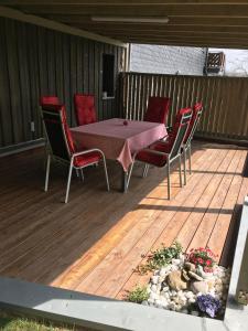 una terraza de madera con mesa y sillas. en Ferienhaus Michels, en Hellenthal