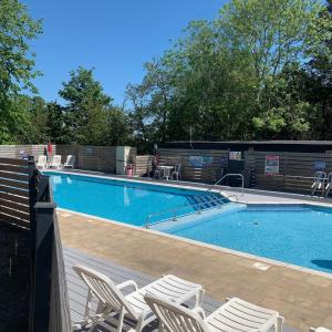 una piscina con sillas blancas al lado en The Bliss en Hastings