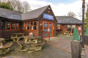 a wooden cabin with picnic tables in front of it at The Bliss in Hastings