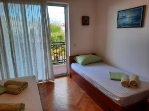 sypialnia z 2 łóżkami i drzwiami na balkon w obiekcie Holiday Home Marija w mieście Vantačići