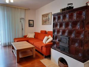 salon z pomarańczową kanapą i kominkiem w obiekcie Holiday Home Marija w mieście Vantačići