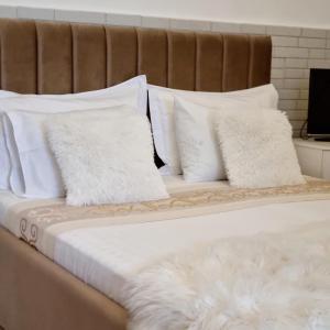 a bed with white pillows on top of it at Green Villa in Vlorë