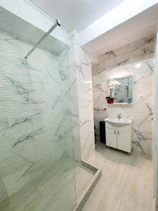 a bathroom with a glass shower and a sink at Coral Residence -Mamaia Nord in Mamaia +151 photos