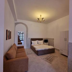 a bedroom with a bed and a couch at Green Villa in Vlorë