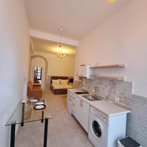 a kitchen with a washing machine and a living room at Green Villa in Vlorë