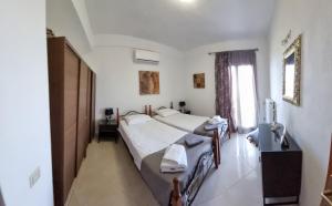 a bedroom with two beds and a sink and a mirror at Stathi's House in Megali Ammos
