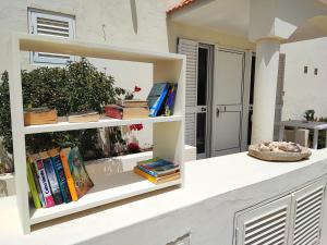 una libreria con dei libri sopra accanto a una casa di Casa Djarmai Apartments a Vila do Maio