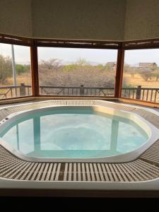 bañera de hidromasaje en la cubierta de una casa en Luna rossa 19 Zebula golf course and spa resort, en Mabula