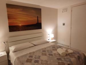 a bedroom with a bed with a painting on the wall at Villa Oblò in Favignana