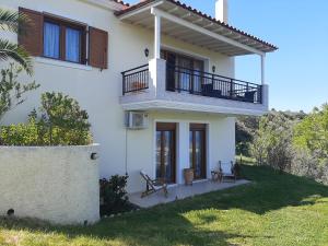 a white house with a balcony and a porch at Stathi's House in Megali Ammos