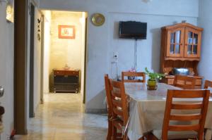 comedor con mesa, sillas y TV en Eluney Apart en Villa Giardino