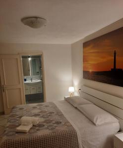 een slaapkamer met een bed en een schilderij aan de muur bij Villa Oblò in Favignana