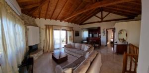 a large living room with a couch and a tv at Stathi's House in Megali Ammos