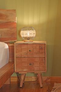 a lamp on a wooden dresser next to a bed at Picollo Grecia Residence Panoramic View in Ermoupoli +7 photos