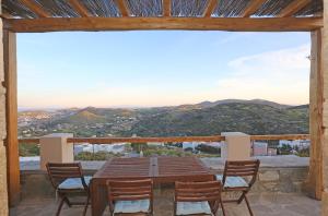 a table and chairs on the balcony of a house at Picollo Grecia Residence Panoramic View in Ermoupoli