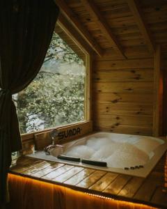 a bath tub in a wooden room with a window at Sumda Konaklar in Çamlıhemşin