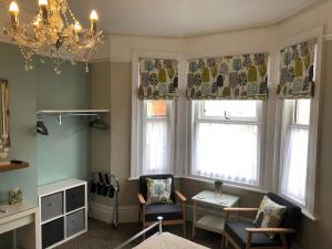 a living room with two chairs and a chandelier at The Ryedale in Shanklin