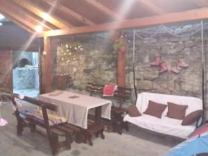 a room with a table and chairs and a stone wall at Privatni smještaj Kurtalija in Jajce