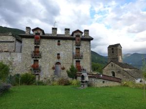 un antiguo edificio de piedra con una torre de reloj. en La Abadía de Fragen-Ordesa, en Torla