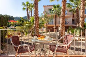 a table and chairs on a patio with palm trees at Apartamentos Mundaka Albir in Albir