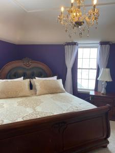 um quarto com uma cama grande e um lustre em Seabank House Bed and Breakfast The Royal em Pictou