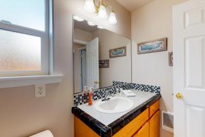 un baño con lavabo y espejo en True North, en Rockaway Beach 14 fotos más
