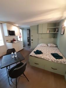 Un dormitorio con una cama y una mesa. en Studio équipé métro Abbesses à Montmartre, en París