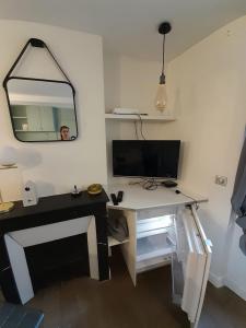 Habitación con escritorio, TV y espejo. en Studio équipé métro Abbesses à Montmartre, en París
