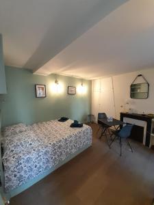 1 dormitorio con 1 cama y 1 mesa con sillas en Studio équipé métro Abbesses à Montmartre, en París
