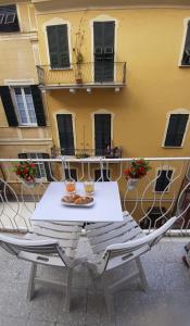 een witte tafel en stoelen op een balkon met een gebouw bij La Nena Appartamenti in La Spezia
