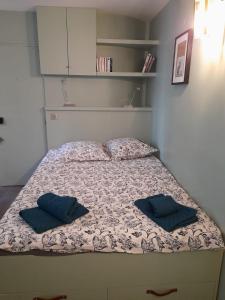 1 cama con 2 almohadas en una habitación en Studio équipé métro Abbesses à Montmartre, en París