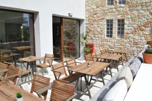 un patio al aire libre con mesas y sillas de madera en IADES suites, en Afitos