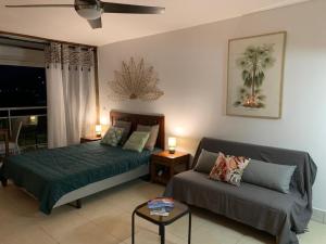 1 dormitorio con 1 cama y 1 sofá en Marigot, Studio front de mer vue exceptionnelle, en Marigot