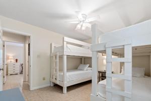 a bedroom with two bunk beds and a ceiling fan at Island House in Dauphin Island