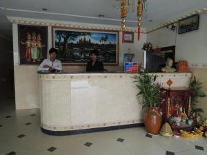 Relax Guesthouse في بنوم بنه: شخصين واقفين في كونتر في مطعم