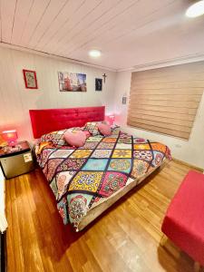 a bedroom with a large bed with a red head board at Habitacion Deluxe, Wi-Fi, desayuno gratis y a minutos del crucero! in San Antonio