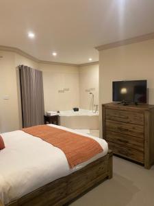 a bedroom with a bed and a flat screen tv at Emerald Creek Cottages in Emerald