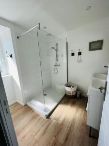 uma casa de banho com uma cabina de duche em vidro e um lavatório. em La Casa D'Alauna em Valognes
