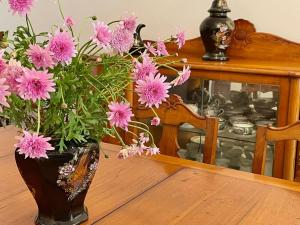 een vaas gevuld met roze bloemen zittend op een tafel bij Casa Às Nove in Angra do Heroísmo