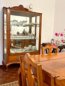 een eetkamer met een tafel en een servieskast bij Casa Às Nove in Angra do Heroísmo