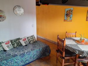 Habitación con cama, mesa, mesa y mesa. en Departemento Solumi Relax en San Bernardo