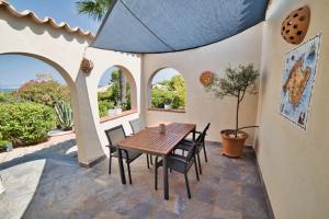 an outdoor patio with a wooden table and chairs at Casa Abeja in Colonia de Sant Pere