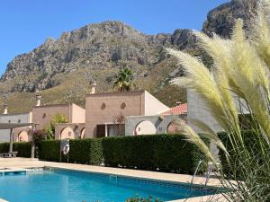 a house with a swimming pool in front of a mountain at Casa Abeja in Colonia de Sant Pere