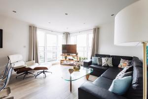 ロンドンにあるBeautiful Central Family Apartment for 6のリビングルーム(黒いソファ、ガラスのテーブル付)