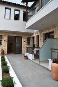 une terrasse en face d'une maison avec un escalier dans l'établissement IADES suites, à Afytos