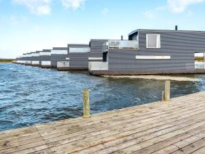 a house on the water next to a dock at 6 person holiday home in Hemmet in Falen