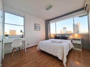 sypialnia z łóżkiem, biurkiem i oknami w obiekcie G&G Apartments - Obelisco River View w BuenosAires