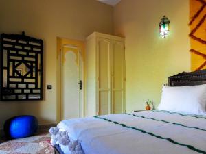 a bedroom with a large bed and a light fixture at Le Bleu House in Marrakech